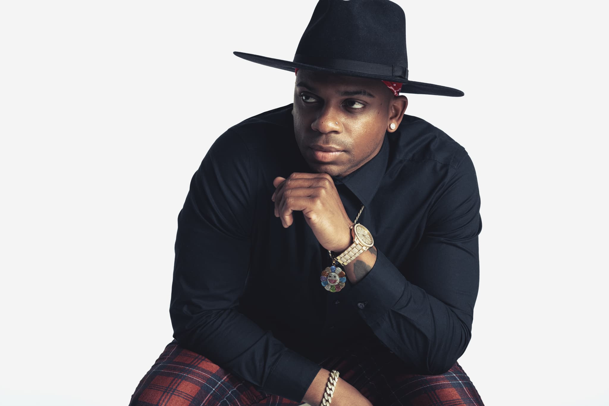 Jimmie Allen dressed in black with a black cowboy hat