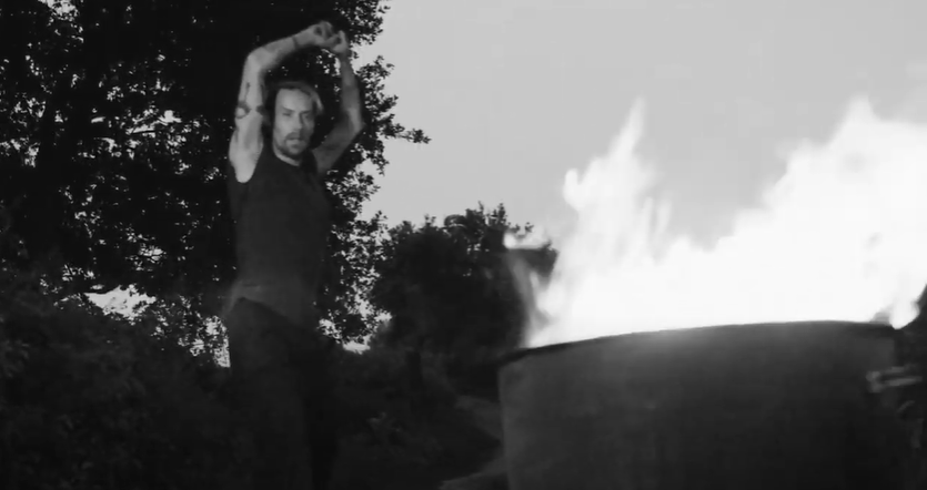 Dancer pirouettes next to a fire pit