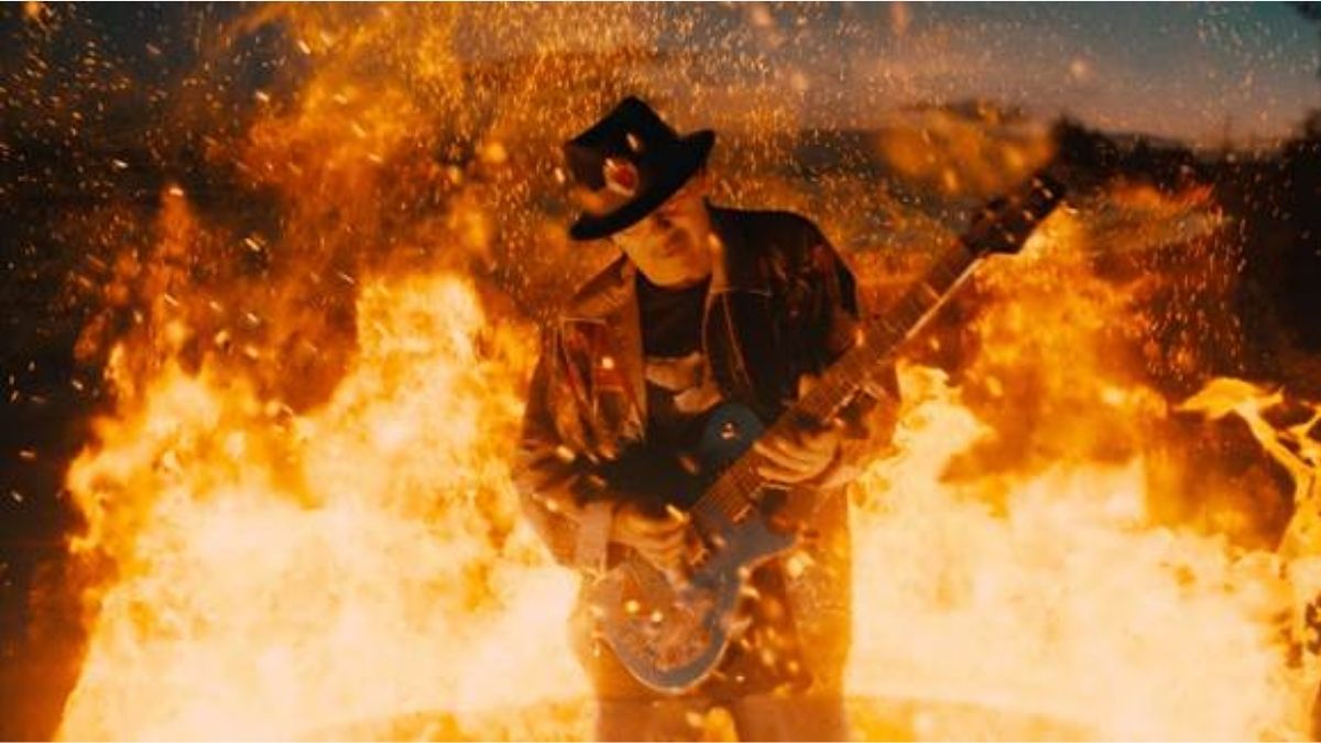 Santana playing guitar surrounded by fire