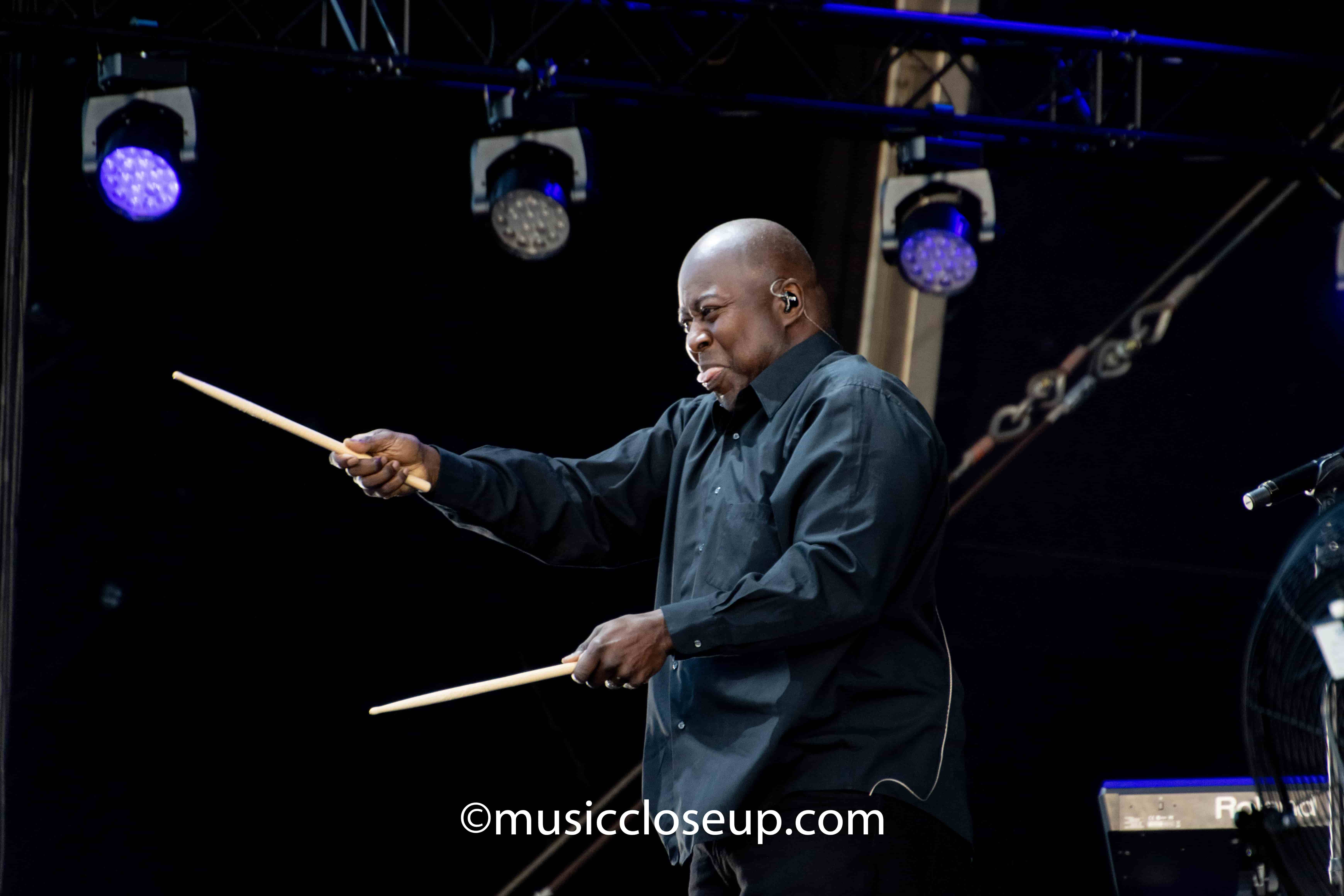 Chic drummer smiling with drumsticks