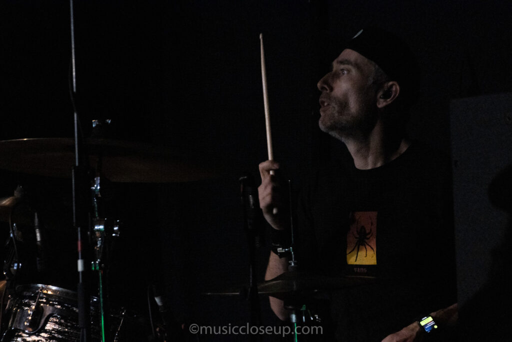 Everclear drummer Brian Nolan holding up a drumstick ready to hit.
