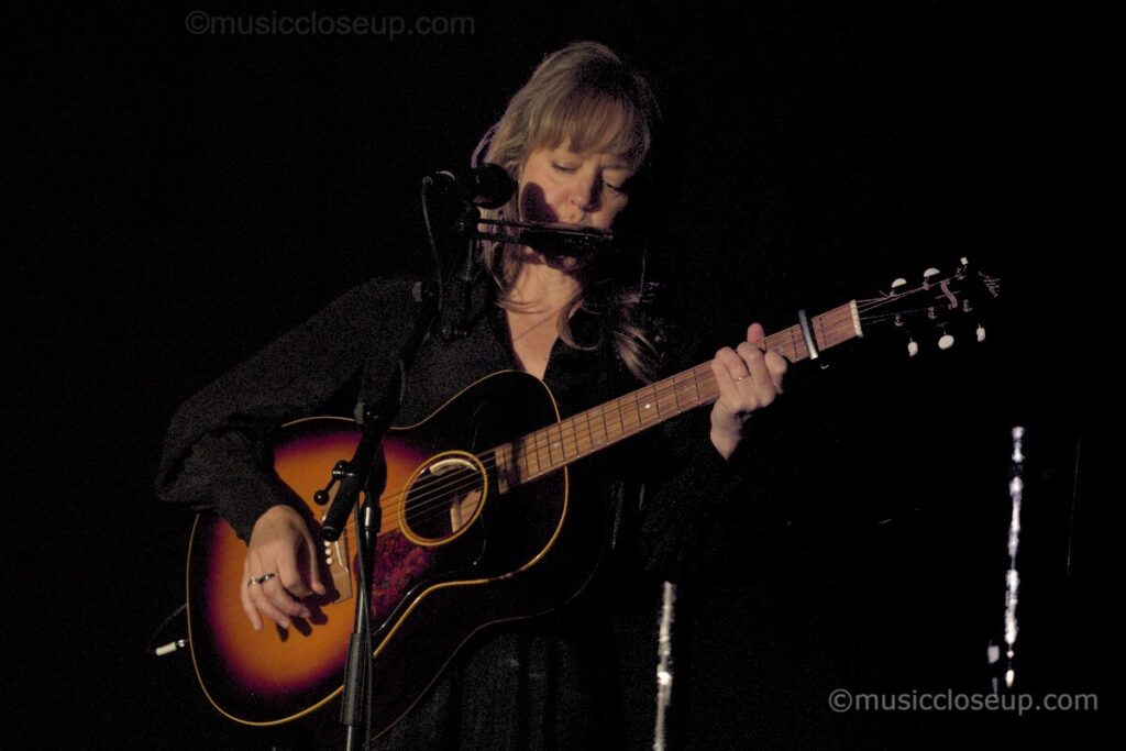 Emily Barker live in Dumfries playing guitar and harmonica on stage