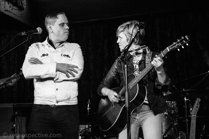 Emily Barker and Austin Lucas defiantly looking each other in the eyes while performing a duet