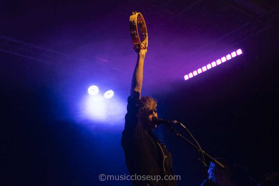 She Drew The Gun live in Lancaster: Louisa Roach holding a tambourine high