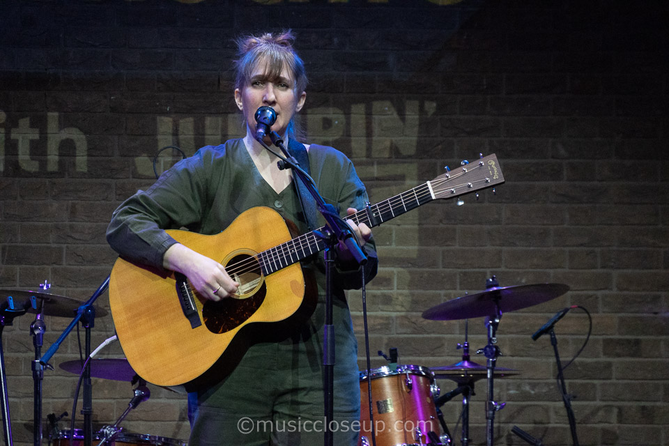 Annie Dressner playing guitar on stage