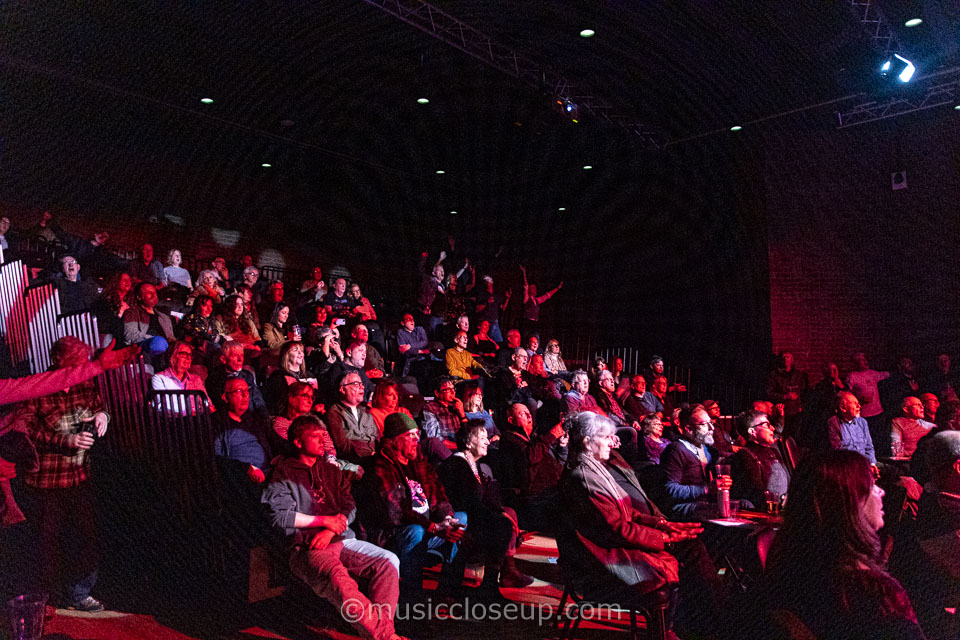 The audience at Gosforth Civic Theatre with a group standing, dancing and cheering
