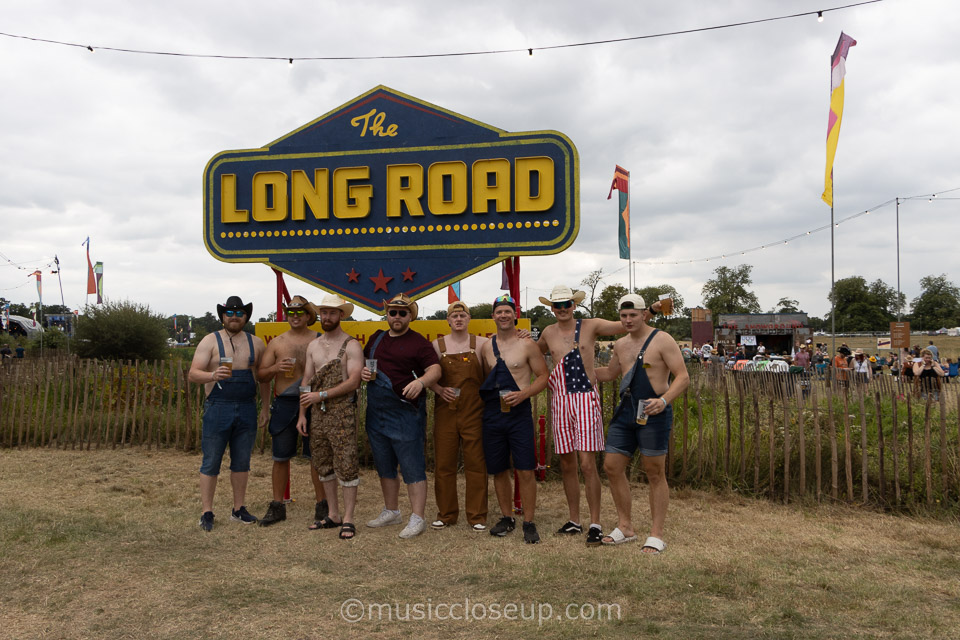 The Long Road Festival 2025 review: photo of men in cowboy hats and dungarees standing on front of The Long Road Festival sign